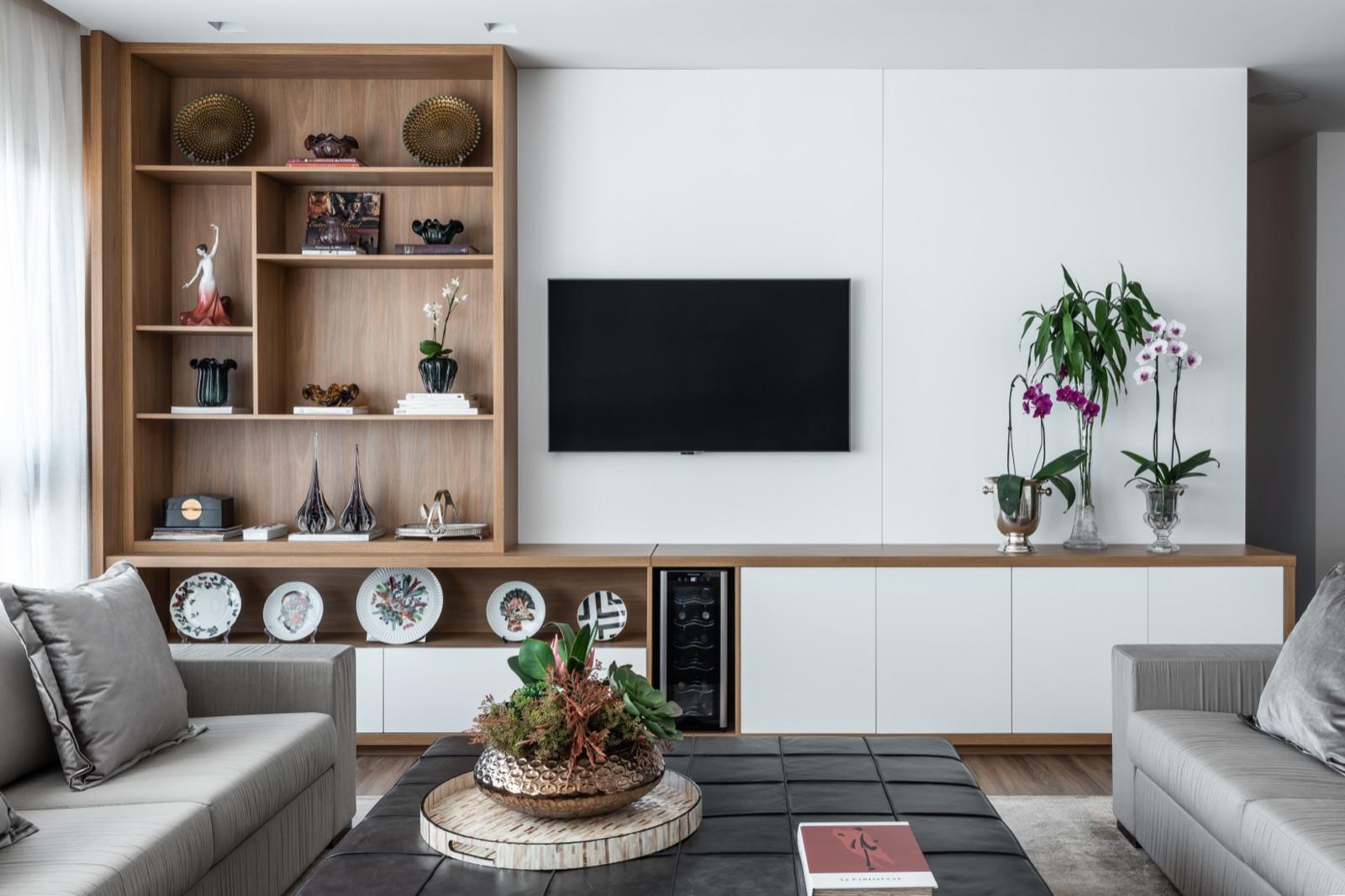 Estante de sala com nichos, painel em laca e iluminação embutida.